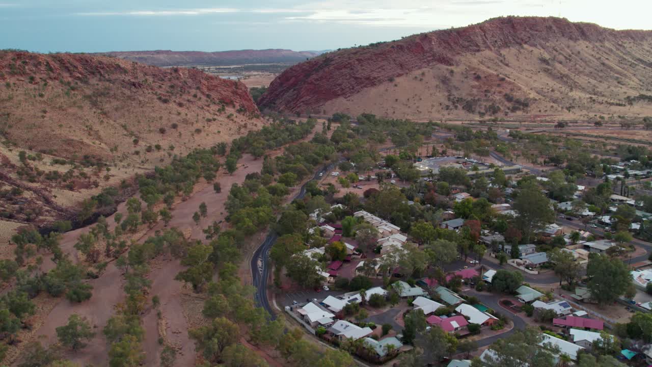 Reversing drone footage of The Gap, a suburb of Alice Springs, Mparntwe, with The Todd River and Heavitree Gap in the distance. Northern Territory, Australia. August 2022.