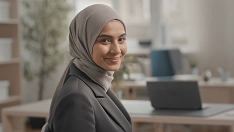 smiling professional woman in hijab in an office