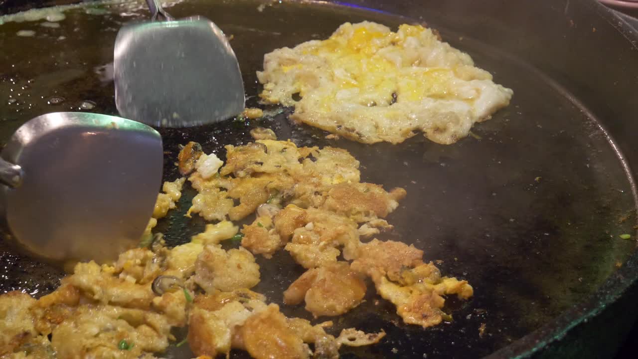 Asian thailand street food scrambled egg with oyster at street food night market cooking