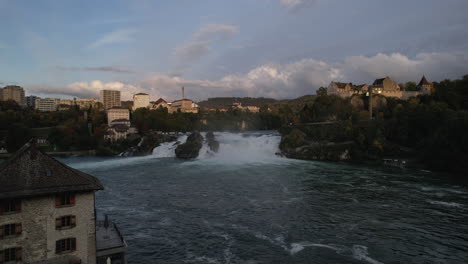 Fantástica-Toma-Aérea-En-Aproximación-Pasando-Por-Un-Edificio-Y-Acercándose-A-Las-Cataratas-Del-Rin-Y-Donde-Se-Puede-Ver-El-Castillo-De-Laufen