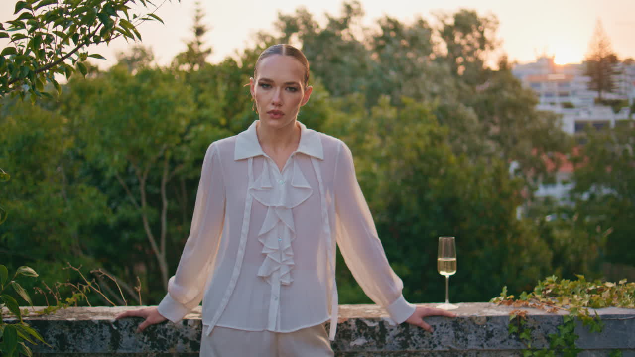 아름다운 여인 휴식을 취하는 발코니 와인 유리창과 함께 오래된 건물. 여자 나무 포즈