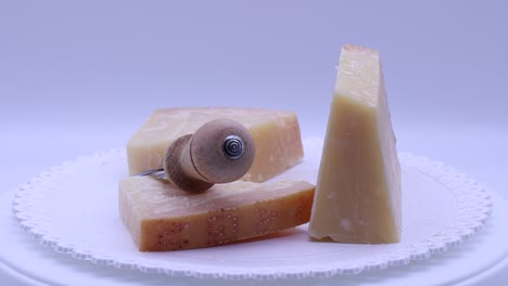 Italian-Parmigiano-Reggiano-cheese-with-cheese-knife-rotating-on-a-turntable