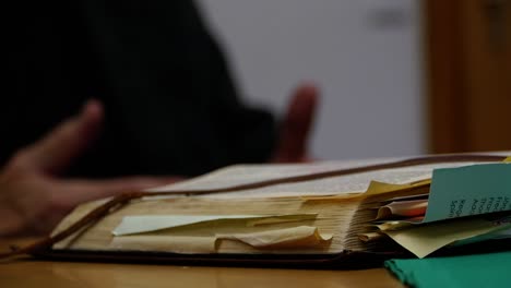 old and used book, man leads a discussion in the background