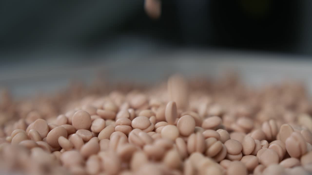 Slow motion shot of granules for milling machine coolant falling down and creating a pile of granules