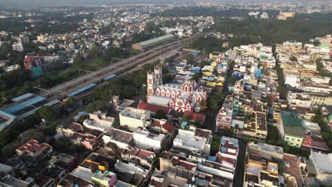 Toma-Aérea-De-Un-Dron-De-Una-Estación-De-Tren-Cerca-De-Una-Vía-Férrea-Con-Un-Edificio-Cercano