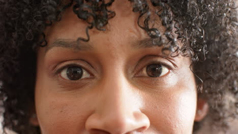 portrait close up of brown eyes of happy african american woman smiling in sun, slow motion