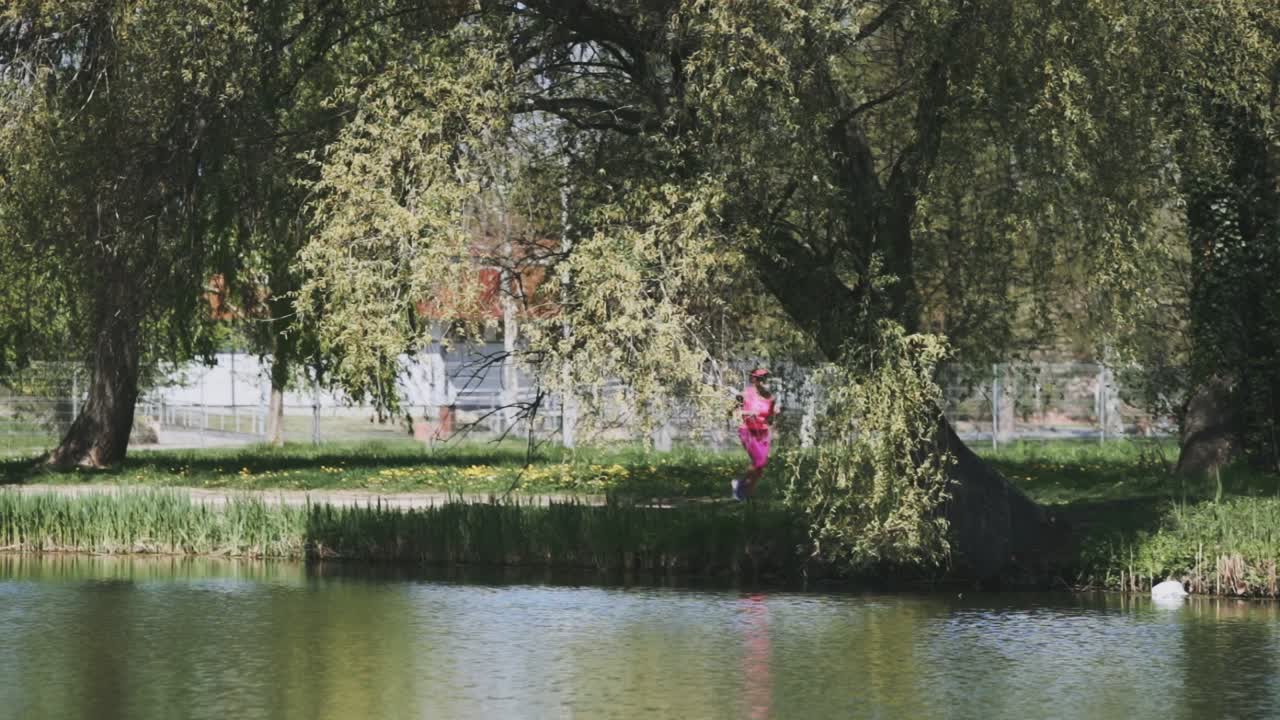 한 여자가 호수 근처에서 앞으로 달리고 있다