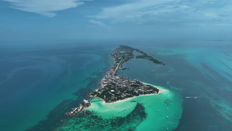 Aerial-view-overlooking-the-Isla-Mujeres-island-in-sunny-Mexico---reverse,-drone-shot