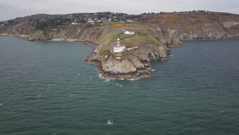 Baily-Lighthouse-On-Howth-Head-Peninsula-With-Blue-Sea-In-Foreground-In-Dublin,-Ireland