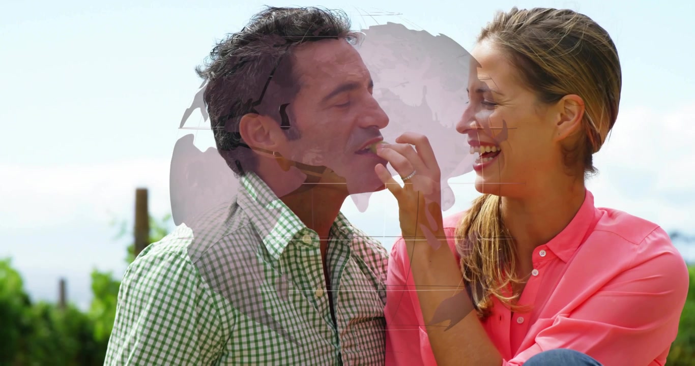 Woman offering red berry to man while rotating globe overlay illustrating global health marketing