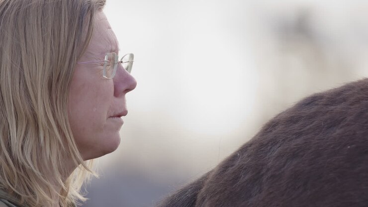 Woman with tears on cheek processes emotions, equine-facilitated counselling
