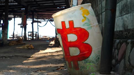 toma de enfoque completo, un tambor blanco con un logo rojo de bitcoin al costado de la cabaña en la playa de bitcoin en el salvador, méxico, un perro durmiendo en medio de la cabaña