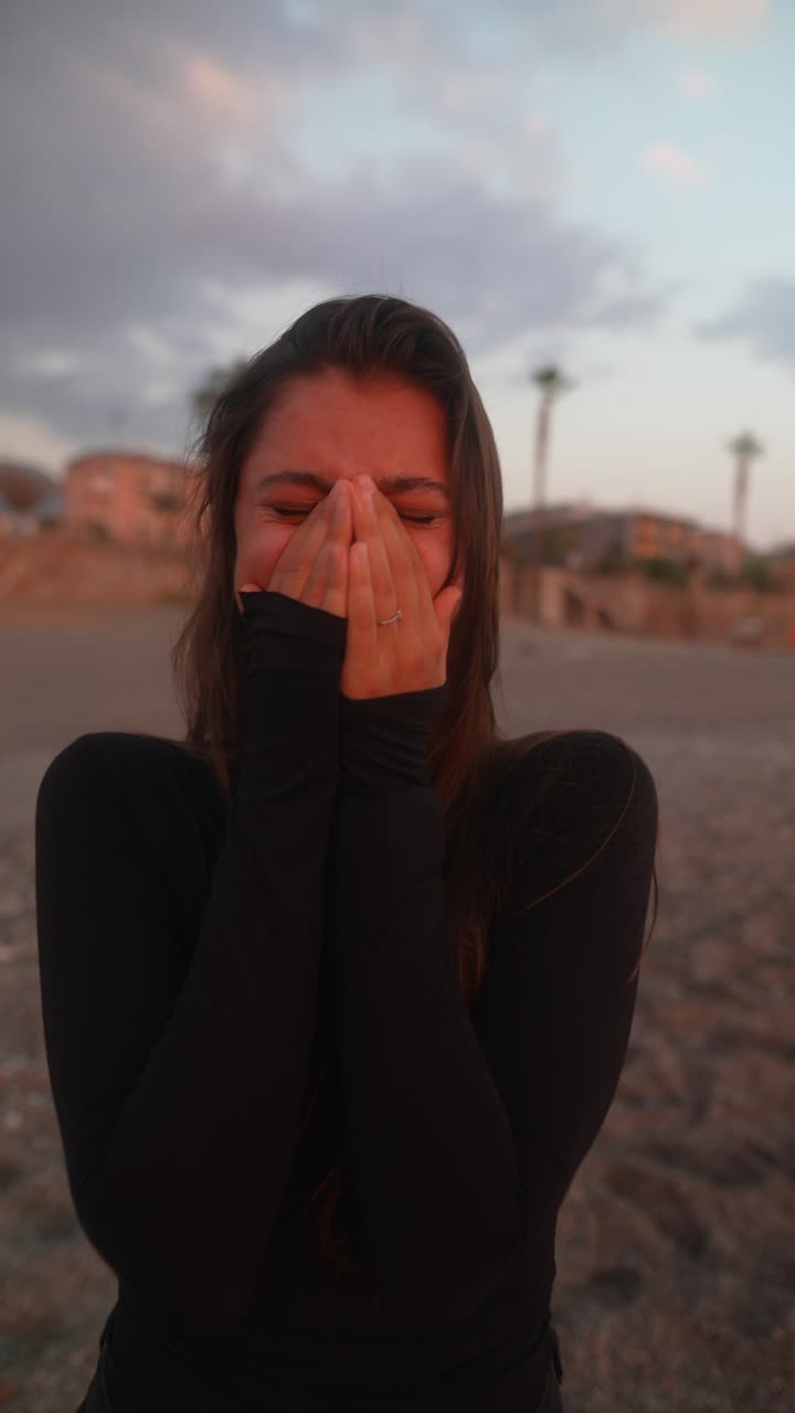 mujer riendo en la playa al atardecer