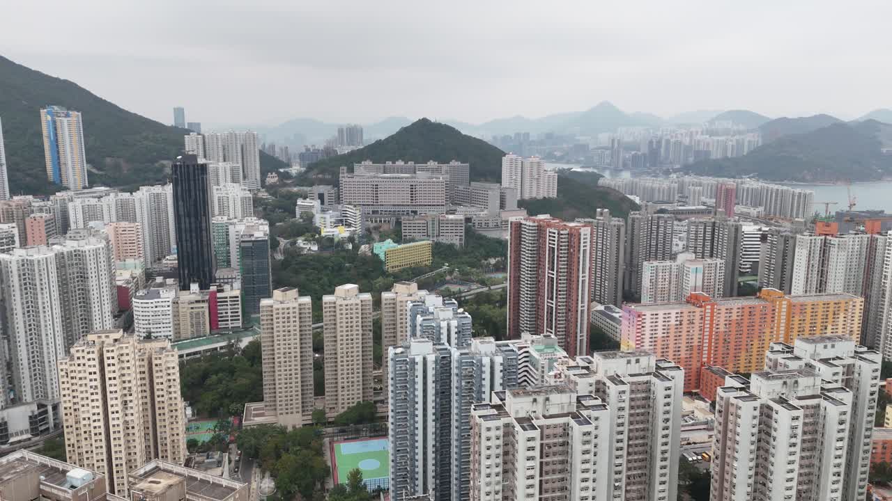 Vista aérea detalhada e próxima de um arranha-céu alto em Hong Kong, capturada por drone. Exibindo fachada moderna de vidro, design de arranha-céu e arquitetura urbana de uma perspectiva elevada.