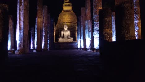 Inclinar-Hacia-Arriba:-Parque-Histórico-De-Sukhothai,-Tailandia,-Escultura-De-Buda-Iluminada-Por-La-Noche.