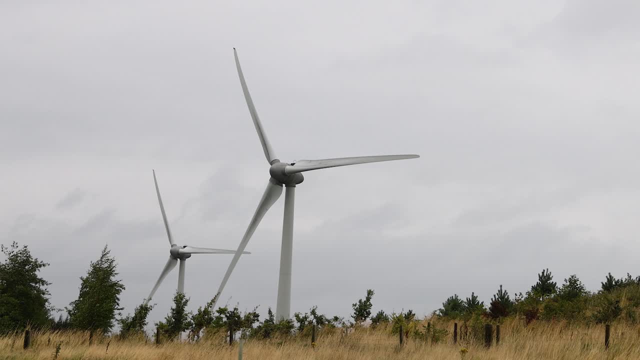 ветряные турбины, вращающиеся в травяном поле