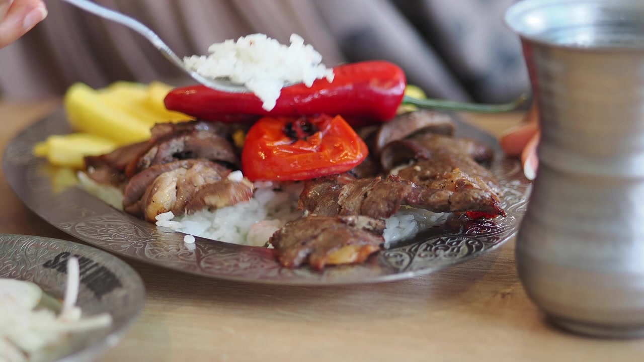 Persona che mangia Doner Kebab turco tradizionale con riso e verdure