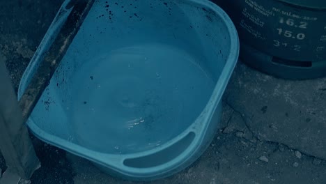 water drops fall into large blue basin with clear water