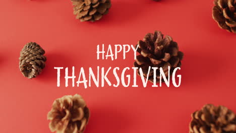 Animation-of-happy-thanksgiving-text-and-pine-cones-on-red-background