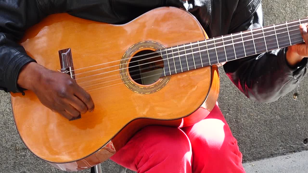 Il musicista suona la chitarra e canta per strada.