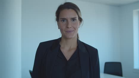 Happy-friendly-young-businesswoman-standing-in-office