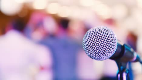 Close-up-of-a-microphone-with-people-dancing-in-the-background