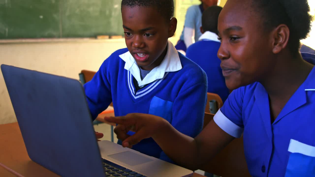 Schoolchildren using laptop in a lesson at a township school 4k