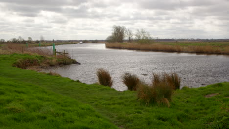 Wide-shot-of-the-river-Bure-with-a-white-board-cruiser-in-background