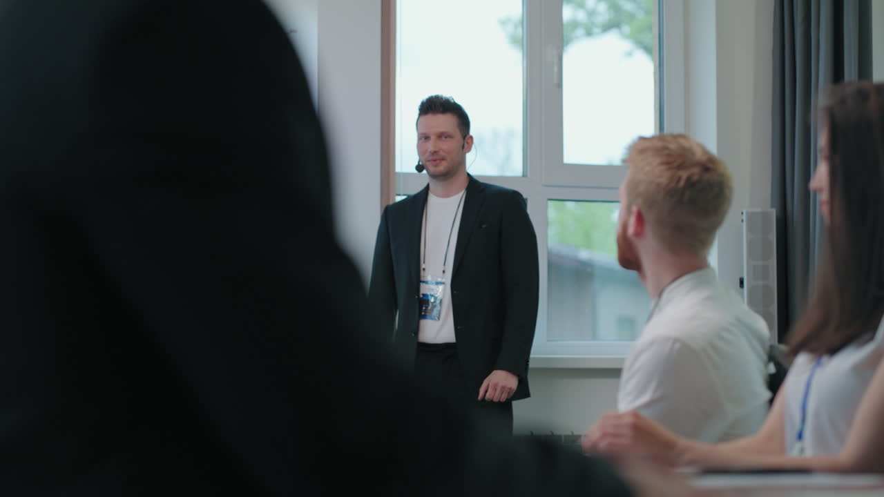 el entrenador de negocios está dando la bienvenida a la audiencia la gente lo está aplaudiendo el hombre carismático está hablando