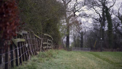 Shot-of-a-fence-running-along-a-field-on-a-farm