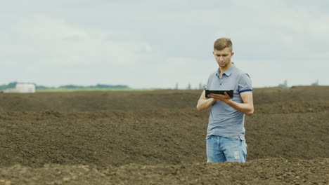 the farmer works near a pile of organic fertilizer - compost