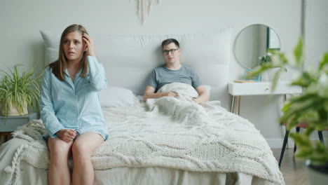una pareja discutiendo en la cama.