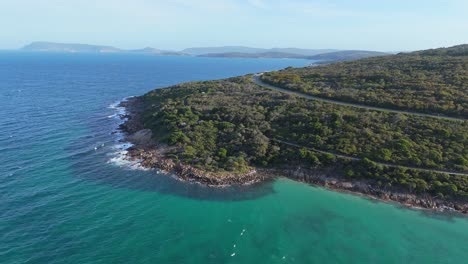 Drone-flying-beside-coastal-mountain-lookout-point-with-winding-road