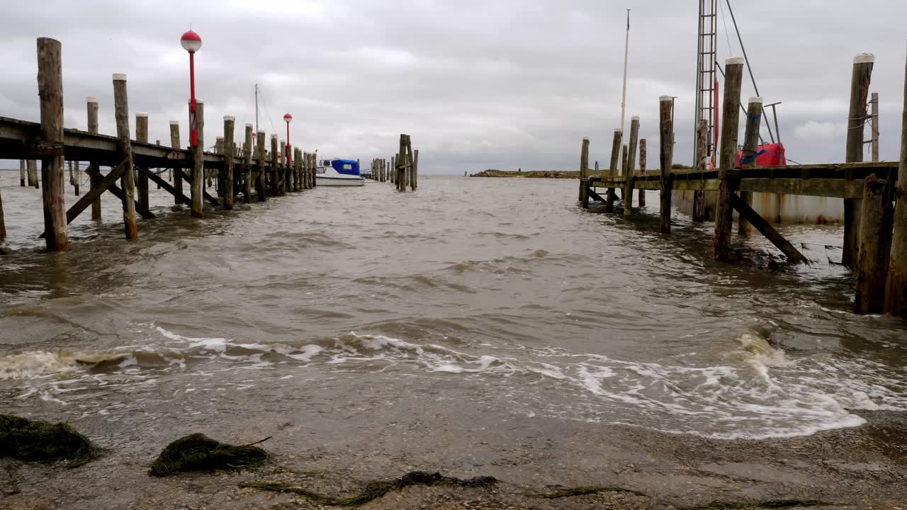 Waves hitting the pier of a small harbor in Rantum, Sylt