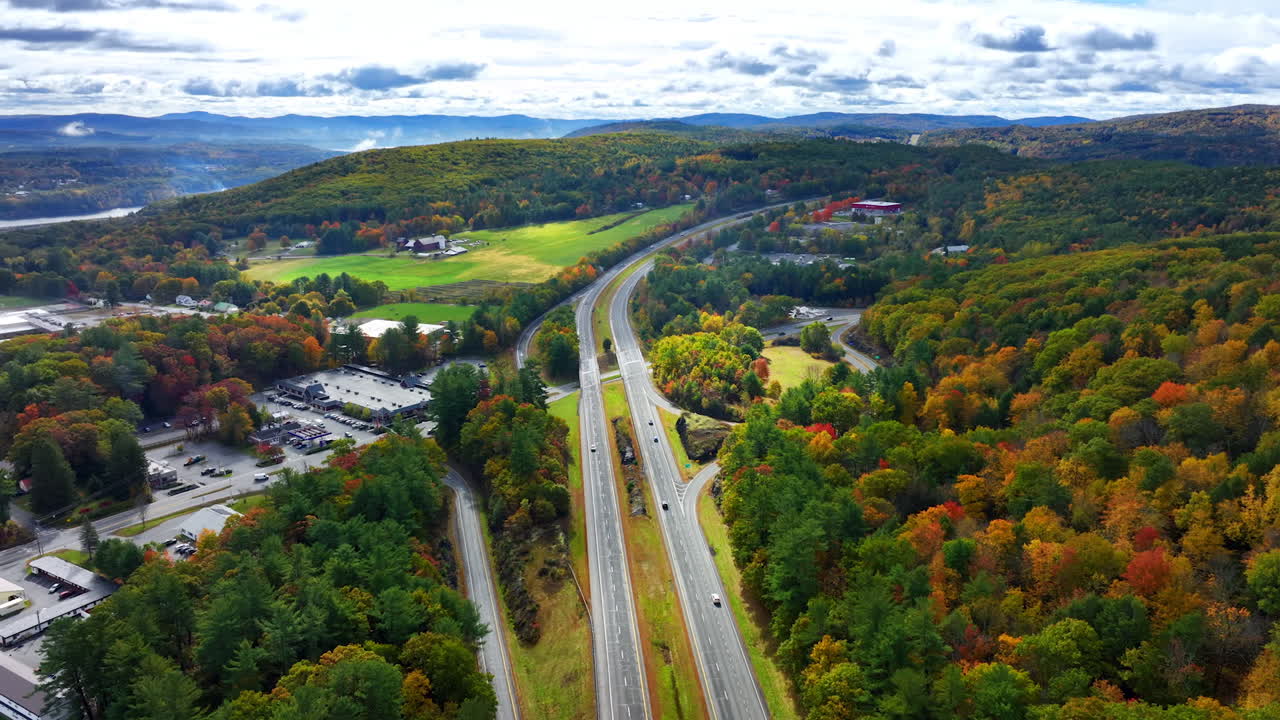 Highways in the picturesque outskirts of Vermont, New England, USA in autumn. Flight above the beautiful panorama with colorful woods.