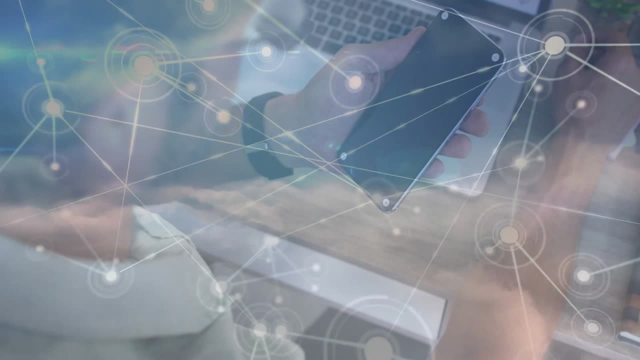 Man scrolling smartphone over laptop keyboard causing tech network graphic to visualize data flow