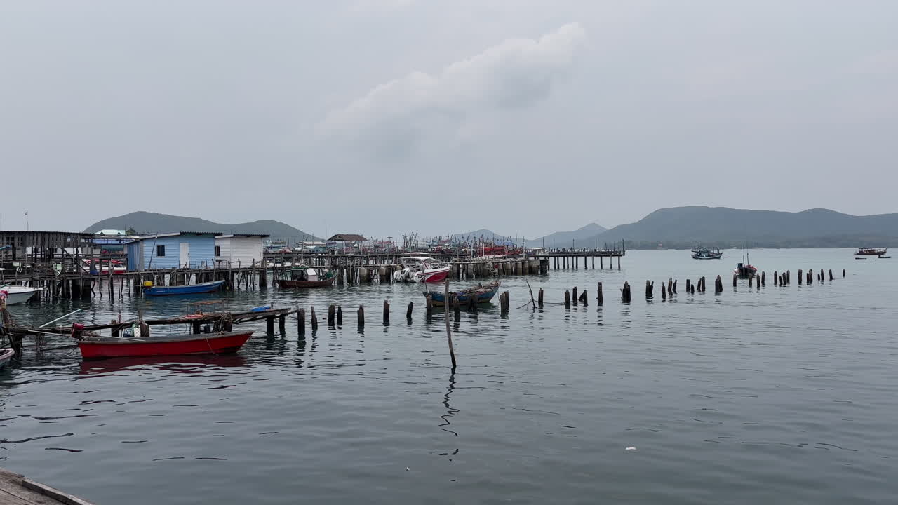 Tayland'daki Samae San Adası yakınlarında teknelerle dolu balıkçı limanı. Seyahat, balıkçılık endüstrisi ve deniz kenarı yaşam tarzı içeriği için uygun, sakin bir sahil köyü manzarası.