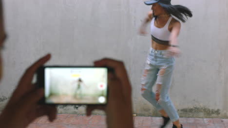 mujer bailando afuera, siendo grabada por otra mujer