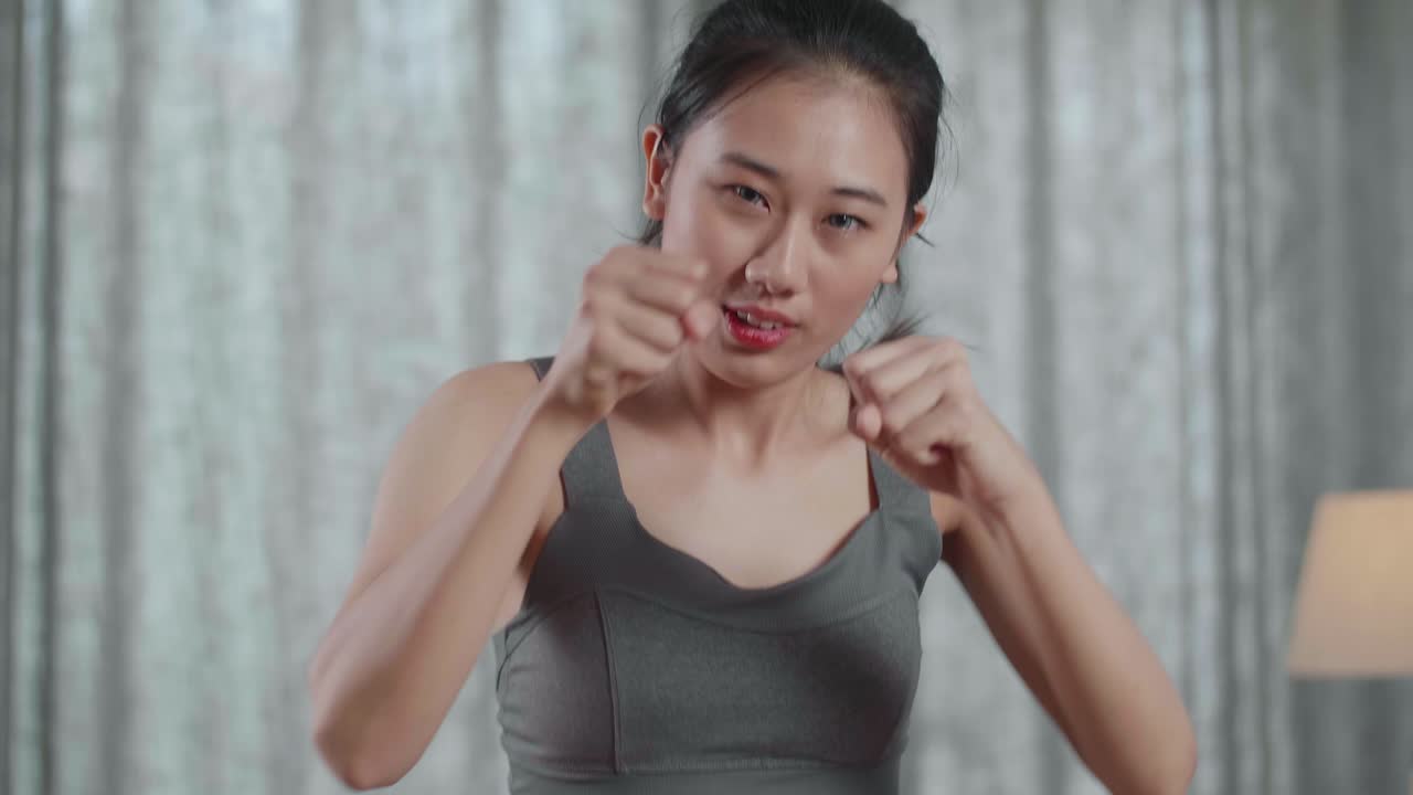 스포츠 옷을 입은 젊은 아시아 운동선수 여성의 근접 초상화가 집에서 매트에서 심장 근본 강화 운동을 하고 있습니다.