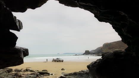 blick durch die höhle zum strand mit auto, das wasserski schleppt, st