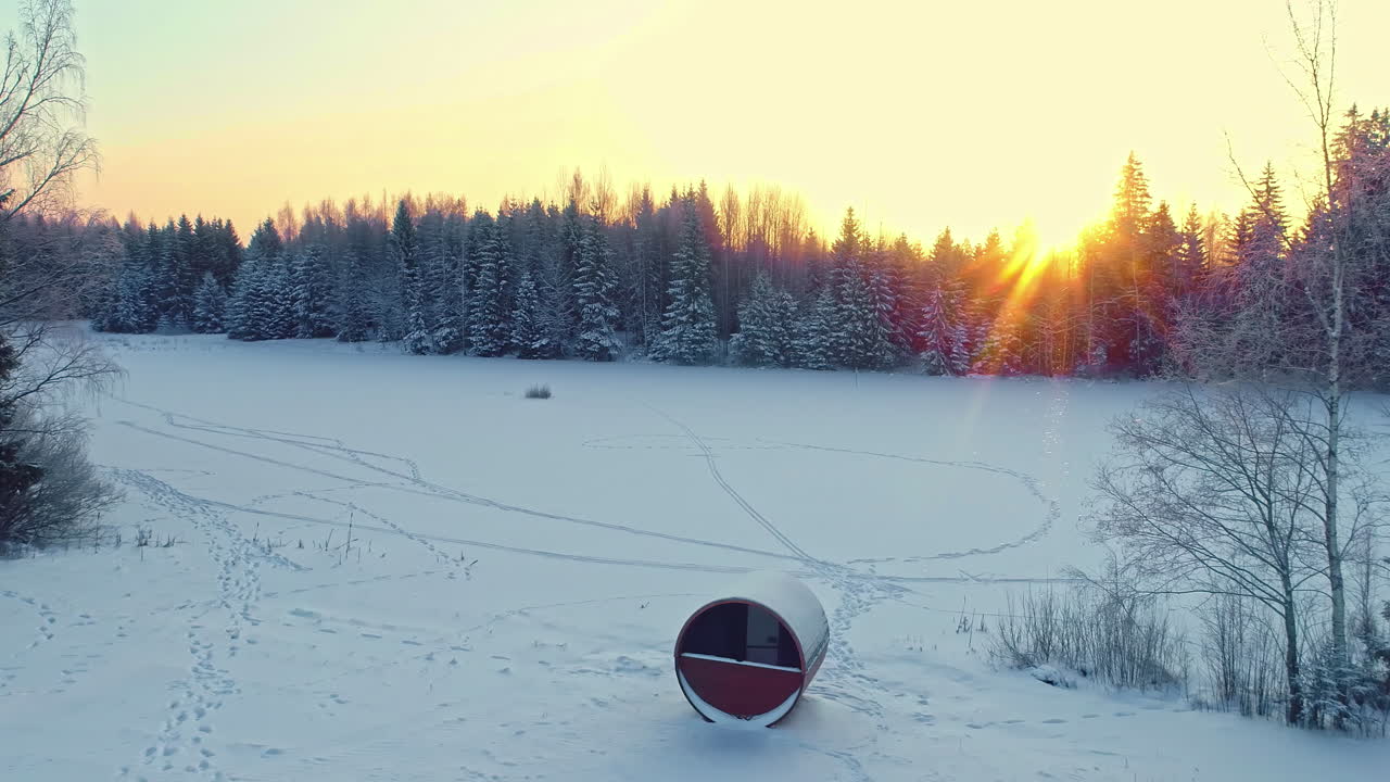 una toma inversa de la vista del amanecer entre los bosques y un paisaje cubierto de nieve