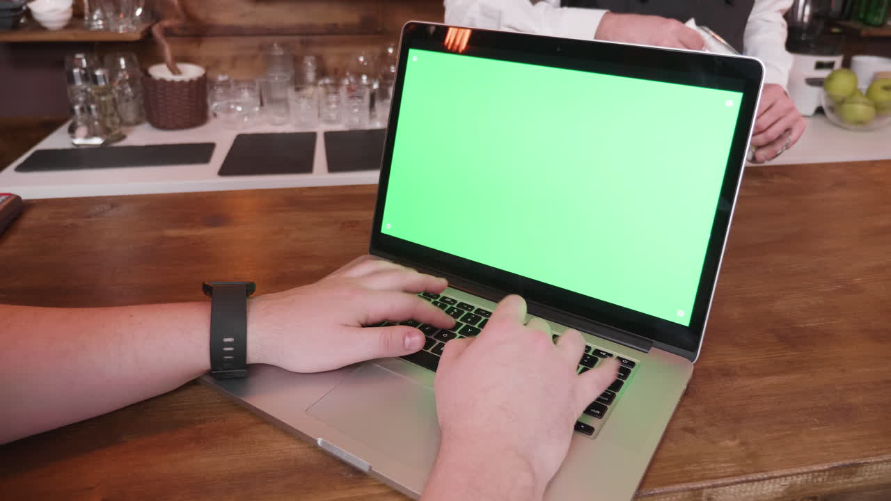 Laptop with green screen at a bar