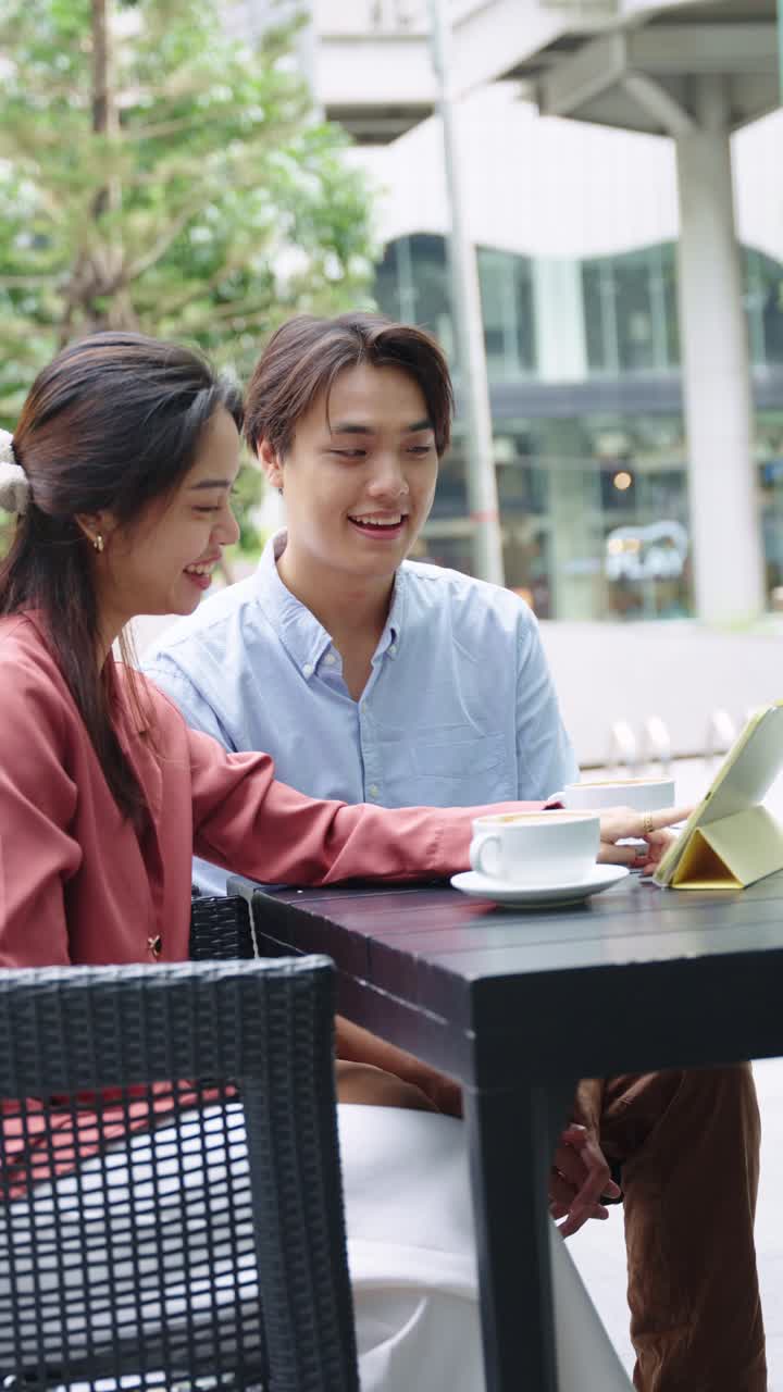 Couple at a cafe looking at a tablet