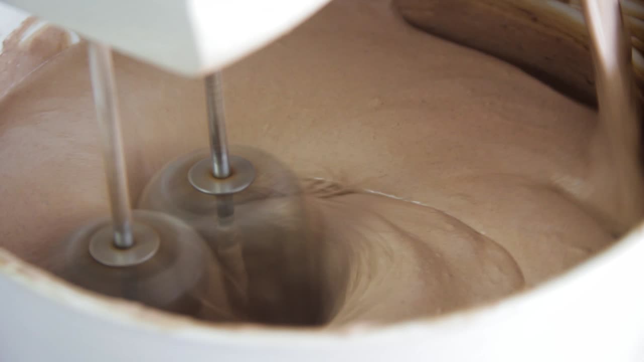 Primo piano di un'impastatrice che prepara l'impasto per una torta al cioccolato