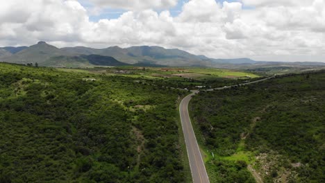 aerial shot of mountainous green landscape and highway