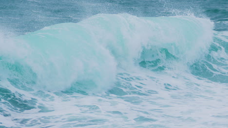 olas del mar creando cresta tocando la costa rocosa
