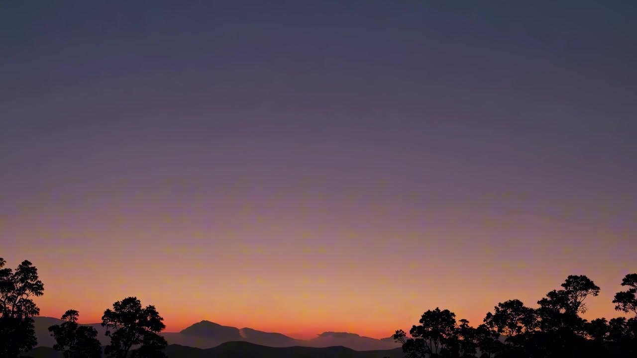 山脈とシルエットの木々越しの夕焼けタイムラプス