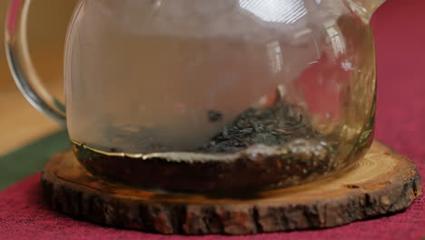 preparar té en una tetera de vidrio