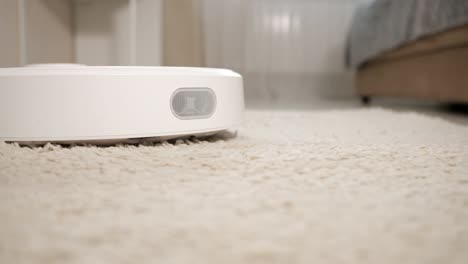 automatic robot vacuum cleaner hoovers beige fluffy carpet