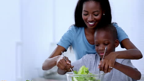 Madre-Enseñándole-A-Su-Hijo-Cómo-Mezclar-Ensalada